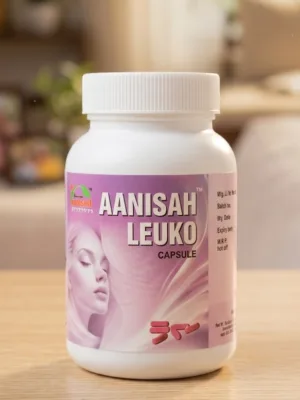 A photograph of a white bottle containing Aanisah Leuko capsules for female health, with a pink label featuring an illustration of a woman's face. The bottle is placed on a light wooden table against a blurred background of a living room with plants and a window.